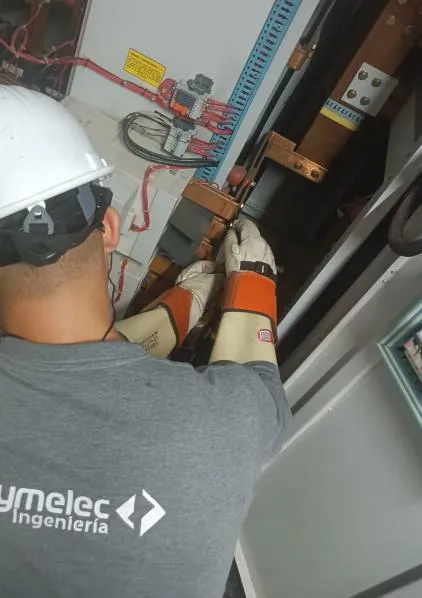 Técnico de Proymelec revisando un barraje con guantes dieléctricos