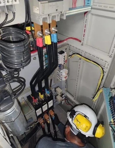 Técnico conectando cables de potencia con terminales de colores